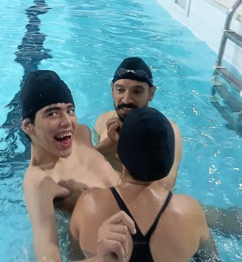 Participante e professor na piscina, sorrindo