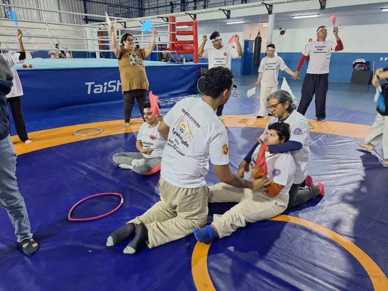 Professor e aluno sentados no tatame durante a dinâmica
